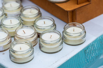 A row of small glass jars with candles in them