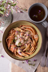 Pancake noodles, pancake spaghetti with meat sauce, cheese and sour cream in a deep plate.
