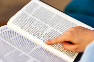 Closeup and shallow focus of child's hand while reading the Bible