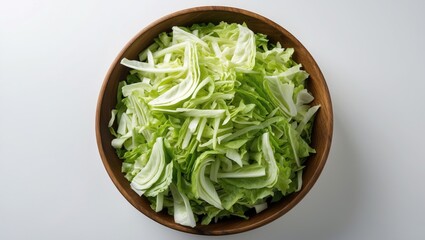 Sliced romaine and napa cabbage in a wooden bowl on a white background, top view