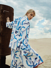 Blonde girl model in a blue suit, shooting in the desert.