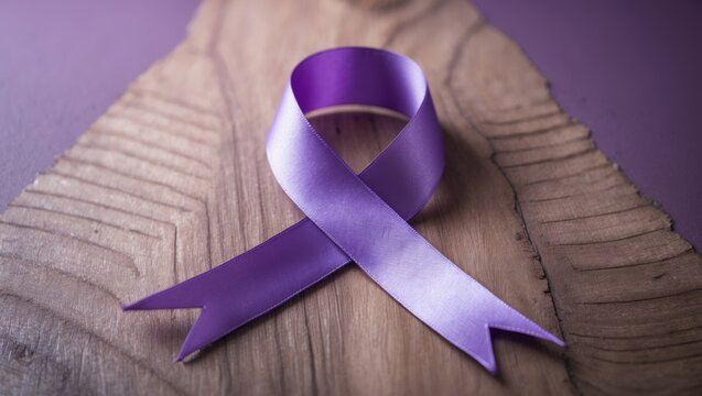Purple ribbon on wooden surface to promote awareness of elder abuse, disease prevention, and health support with ample copy space
