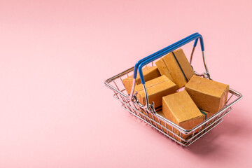 Online shopping concept.Cardboard box and shopping bags in a trolley on a bright colored background. Shopping basket. Online shopping using a laptop, tablet, phone and credit card. Home delivery.