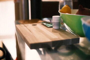 A highly detailed photo of a bowl of fruit sitting on top of a wooden table with artistic lighting. weather: . mood: moody and dramatic.