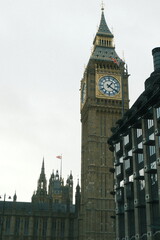 A highly detailed photo of a large building with a clock on it ' s side with artistic lighting. weather: . mood: moody and dramatic.