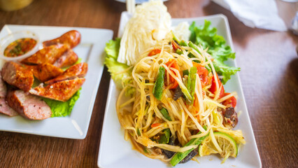 Papaya salad, Thai or Laos cuisine. Unique fruit salad mixed with fermented crab, hot pepper, mini tomatoes, green beans, fish sauce. Delicious appetizer. Eaters can order different level of spiciness