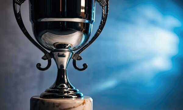 Shiny trophy on marble base with glowing blue background