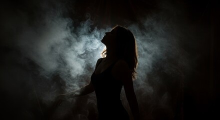 Fototapeta premium Silhouette of Woman in Smoke - A woman's silhouette is bathed in ethereal smoke, symbolizing mystery, transformation, freedom, sensuality, and the ephemeral nature of life