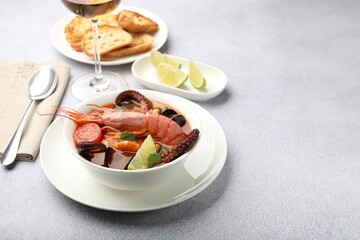 Tasty seafood soup served on light grey table, space for text