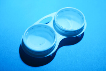 Contact lenses in case on light blue background, above view
