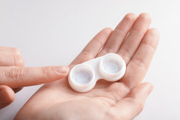 Woman with contact lenses on light background, closeup