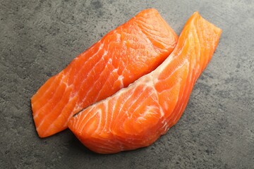Seafood. Pieces of salmon fillet on gray textured table, top view