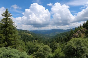 Obraz premium Serene Mountain Vista: Lush Green Forests Under a Cloudy Sky