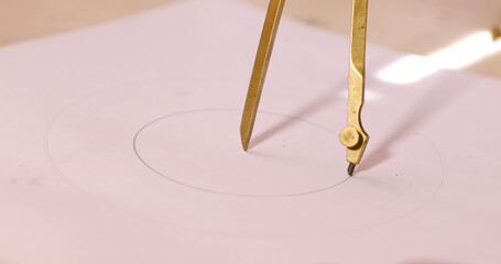 On white paper a compass draws a circle