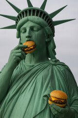 Obraz premium Statue of liberty eating burgers: american fast food culture