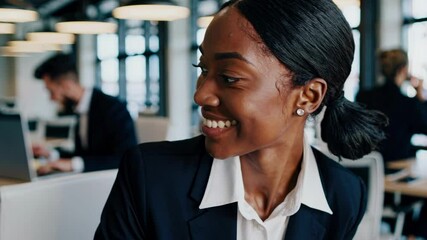 A dynamic video still of a smiling professional woman in a modern office. Captured from a close-up angle, highlighting a vibrant, collaborative workspace.
