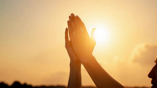 Hopeful hands raised to sun at sunset. Person showing gratitude with hands raised towards evening sun. Spiritual prayer concept image for meditation, yoga, or mindfulness. Hopeful hands raised to sun