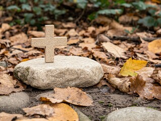 Small stone cross on a rock surrounded by autumn leaves