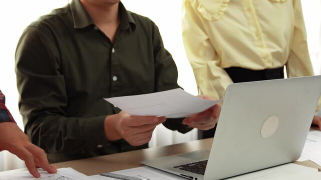 Safety engineer praising skilled architect success design building blueprint project on laptop with architectural document and measurement tool scatter around at modern office. Closeup. Delineation.