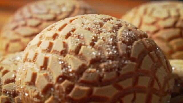 Close Up of Delicious Conchas Mexican Sweet Bread with Sugary Shell Topping on Wooden Table in Warm Lighting