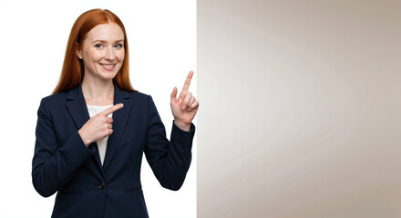 Smiling redhead businesswoman pointing finger up on neutral beige background. Professional in navy suit with white top showing attention gesture. Business idea with copy space. Leadership banner