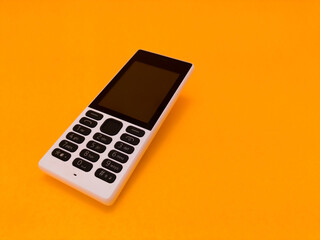 old mobile phone against a bright orange backdrop