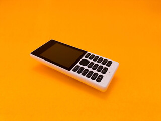 old mobile phone against a bright orange backdrop
