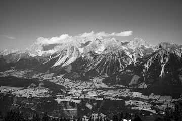 Obraz premium Mountains rise majestically in the background, showcasing the Dachstein range from the vantage point of Planai. The lush valleys below contrast beautifully with the rugged peaks.