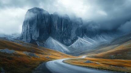 Winding road through autumnal mountain pass, dramatic clouds. Landscapes