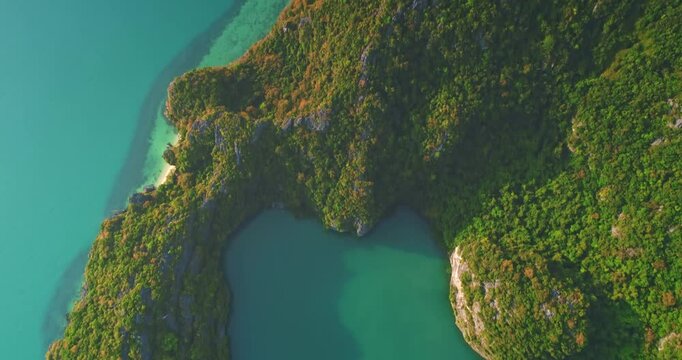 Aerial view capturing Thale Nai lagoon, a turquoise saltwater lake on Koh Mae Ko, embraced by lush tropical vegetation in Moo Koh Ang Thong National Marine Park, Thailand