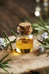 A bottle of rosemary essential oil on a wooden table