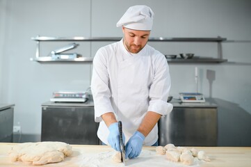 Baker man kneading dough and bakery ingredients. Bakery concept