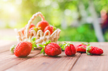 Ripe red strawberries in a basket on a wooden table