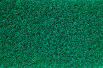 Macro view of the green abrasive surface of a kitchen scrub sponge showing its fibrous texture, ideal for background or texture reference