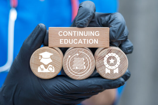 Doctor holding wooden blocks with icons sees inscription: CONTINUING EDUCATION. Continuing education and personal development healt care concept. Continuing professional medicine education.