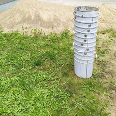 Construction waste. Stack of empty paint cans on sand background.