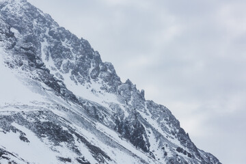Obraz premium Jagged edges of snowy mountains rise sharply in Alaska’s wilderness