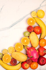 Dragon fruit, pitaya, mango, kiwi, avocado, apples, citrus and oranges on sunny table. Summer banner with tropical exotic fruits and juice with space for text. Healthy vegan food for weight loss