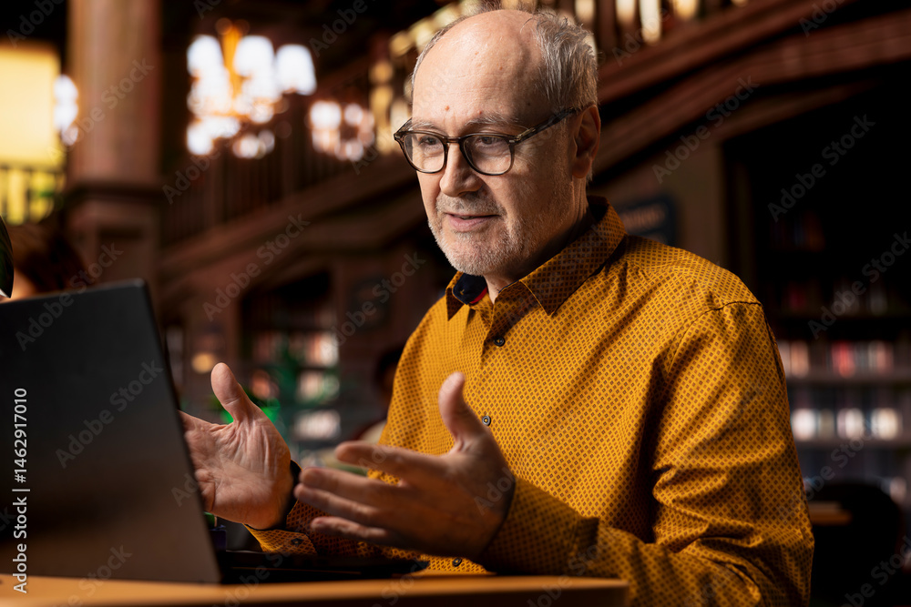 Poster senior man involved in a remote classroom experience via online platform, using wireless internet to