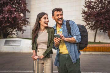 happy tourist couple use their mobile phone to navigate the city
