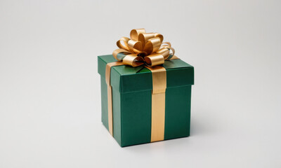 Fototapeta premium A small green gift box wrapped with a golden ribbon, perfect for special occasions and celebrations