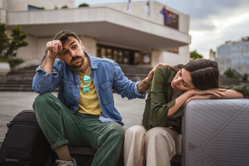 tired and exhausted tourist couple sit on the street need break