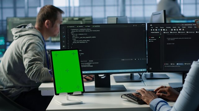 Green screen table in data center in front of IT support specialists working together, supervising server rows. Employees overseeing supercomputers using mockup device, camera A