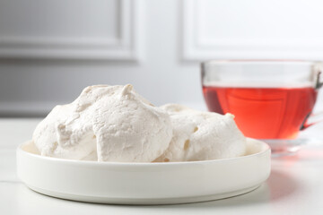 Delicious homemade meringue cookies and tea on light table, closeup
