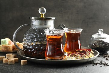 Tasty Turkish tea and delight on black table
