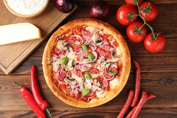 Tasty pizza with smoked sausages and ingredients on wooden table, flat lay