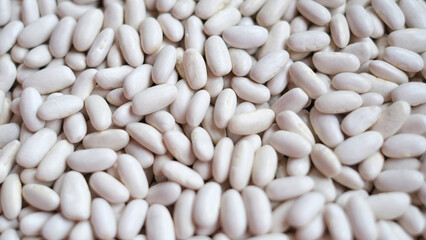 Close-up image of a large pile of white kidney beans, also known as cannellini beans. 