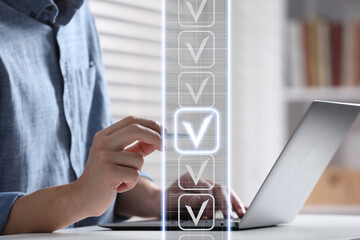 Approved. Man touching check mark on virtual screen above laptop at table, closeup