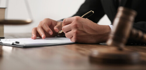 Judge working at wooden table near gavel, closeup. Banner design