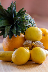 fresh fruits on a wooden table, pineapple, citrus, orange, lemon, ginger 
